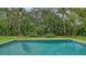 A pristine swimming pool is surrounded by lush landscaping, creating a private and serene backyard oasis at 1682 Hawthorne St, Sarasota, FL 34239