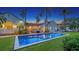 Backyard pool surrounded by palm trees and a well-manicured lawn at dusk at 1682 Hawthorne St, Sarasota, FL 34239