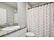This bathroom features a granite vanity, a mirror, and a shower with colorful curtain at 17113 Reserva Dr, Bradenton, FL 34211