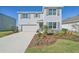 Two-story house with gray siding, stone accents, landscaping, and a two-car garage at 17113 Reserva Dr, Bradenton, FL 34211