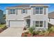 Charming two-story home with well-maintained landscaping, gray paint, and a two car garage at 17113 Reserva Dr, Bradenton, FL 34211