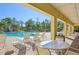 Poolside seating with tables and chairs under a covered patio at 17113 Reserva Dr, Bradenton, FL 34211