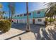 Coastal duplex with light teal exterior, attractive landscaping, and paved driveway at 303 65Th St # A, Holmes Beach, FL 34217