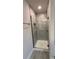 Modern shower with a glass door and gray tile surround, including a built-in niche for storage at 3325 Stockton Ave, North Port, FL 34286