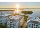 Stunning aerial view of the condo community overlooking a bay with a gorgeous sunrise at 392 Aruba Cir # 403, Bradenton, FL 34209