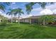 Landscaped backyard with grassy lawn and palm trees at 4442 Cayo Grande Dr # 25, Sarasota, FL 34233