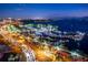 Stunning aerial view of a vibrant coastal city, showcasing a bustling marina and illuminated cityscape at night at 4906 Lighthouse Bay Ln, Bradenton, FL 34211