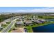 Beautiful aerial view of a suburban neighborhood featuring a screened-in pool and well-maintained landscaping near a lake at 4906 Lighthouse Bay Ln, Bradenton, FL 34211