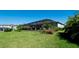 Manicured backyard with lush green lawn and a screened in lanai at 4906 Lighthouse Bay Ln, Bradenton, FL 34211