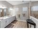 Bright bathroom boasts double sinks, modern vanity, wood-look tile flooring, and a glass-enclosed shower at 4906 Lighthouse Bay Ln, Bradenton, FL 34211