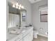 Stylish bathroom features a modern vanity, decorative mirror, and a shower with patterned curtain at 4906 Lighthouse Bay Ln, Bradenton, FL 34211