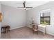 Bright bedroom with a ceiling fan, neutral walls, and a window overlooking the backyard at 4906 Lighthouse Bay Ln, Bradenton, FL 34211