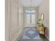 Elegant foyer with decorative wall panels, chandelier, and a blue rug at 4906 Lighthouse Bay Ln, Bradenton, FL 34211