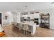 Bright, open kitchen boasts white cabinetry, stainless steel appliances, and a large center island with bar seating at 4906 Lighthouse Bay Ln, Bradenton, FL 34211