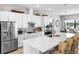 Bright, open kitchen boasts white cabinetry, stainless steel appliances, and a large center island with bar seating at 4906 Lighthouse Bay Ln, Bradenton, FL 34211