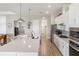 Bright, open kitchen boasts white cabinetry, stainless steel appliances, and a large center island with bar seating at 4906 Lighthouse Bay Ln, Bradenton, FL 34211