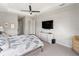 Comfortable main bedroom featuring a tray ceiling, tv, and white dresser at 4906 Lighthouse Bay Ln, Bradenton, FL 34211