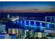 A nighttime view of a city skyline featuring a bridge illuminated with blue lights at 4906 Lighthouse Bay Ln, Bradenton, FL 34211