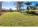 Large backyard with canal view, lush grass, and trees at 5352 Layton Dr, Venice, FL 34293