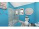 Bathroom with glass enclosed shower, turquoise walls, and decorative mirror at 681 Casey Key Rd, Nokomis, FL 34275