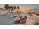 Spacious deck with lounge seating and dining area overlooking ocean and sandy beach at 681 Casey Key Rd, Nokomis, FL 34275