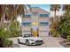 Grand three-story home featuring a modern design with a two-car garage and lush tropical landscaping at 681 Casey Key Rd, Nokomis, FL 34275