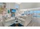 Inviting living room featuring comfortable white sofas, ocean views, and light wood flooring at 681 Casey Key Rd, Nokomis, FL 34275