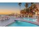 Beautiful pool area with a bridge, outdoor dining, lounge chairs, and stunning ocean views at 681 Casey Key Rd, Nokomis, FL 34275
