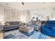 Bright living room with gray sofas, a coffee table, and an open view to the kitchen at 7448 39Th E Ct, Sarasota, FL 34243