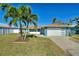 Updated waterfront home with a teal exterior, two-car garage, and lush landscaping at 8 Island Dr, Treasure Island, FL 33706