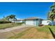 Modern home with a teal exterior, two-car garage, and waterfront view at 8 Island Dr, Treasure Island, FL 33706