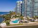 Aerial view of waterfront condo building with pool and tropical landscaping at 888 Boulevard Of The Arts # 1705, Sarasota, FL 34236