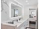 Modern bathroom with double vanity, marble tile, and large mirror at 888 Boulevard Of The Arts # 1705, Sarasota, FL 34236