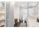 Elegant bathroom with marble walls, a walk-in shower, and a separate toilet area at 888 Boulevard Of The Arts # 1705, Sarasota, FL 34236