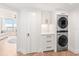 Bright laundry room featuring a stacked washer and dryer and built-in cabinetry at 888 Boulevard Of The Arts # 1705, Sarasota, FL 34236