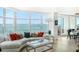 Living room with curved sofa, hardwood floors and water views at 888 Boulevard Of The Arts # 1705, Sarasota, FL 34236