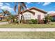 One-story house with a terracotta tile roof, landscaping and palm trees at 10924 Bullrush Dr, Venice, FL 34293