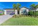 Single-story home with a gray garage door and landscaping at 11200 Balfour St, Venice, FL 34293