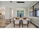 Modern dining room features a wood table, six light-colored chairs, and a large window at 1173 Rotonda Cir, Rotonda West, FL 33947