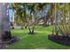 Lush backyard oasis with mature palm trees and well-manicured lawn at 11822 Forest Park Cir, Bradenton, FL 34211