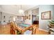 Elegant dining area with wood floors and table, connected to a modern kitchen and living space at 1330 Still River Dr, Venice, FL 34293