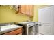 Functional laundry room with front-load washer/dryer, built-in cabinets, and utility sink at 1330 Still River Dr, Venice, FL 34293