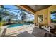 Inviting covered patio featuring a pool, outdoor seating, and relaxing views of the water at 1330 Still River Dr, Venice, FL 34293