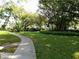 Landscaped grounds with a walkway, lush greenery, and large trees at 2228 Canal Dr # D26, Bradenton, FL 34207
