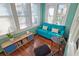 Sunroom with teal couch, wooden floors, and large windows at 2325 Ixora Ave, Sarasota, FL 34234