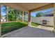 Covered patio with a view of the backyard, featuring a grill and lush landscaping at 24911 Oakhaven Ct, Lutz, FL 33559