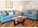 Spacious living room with two blue sofas and an area rug at 3405 Highland W Ave, Bradenton, FL 34205