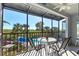 Screened balcony with table and chairs, overlooking pool at 3601 E Bay Dr # 203, Holmes Beach, FL 34217
