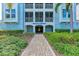 Welcoming building entrance with a brick pathway, lush landscaping, and the building name displayed prominently at 396 Aruba Cir # 103, Bradenton, FL 34209