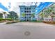 Building exterior showcasing its light blue color, multiple balconies, and palm trees at 396 Aruba Cir # 103, Bradenton, FL 34209